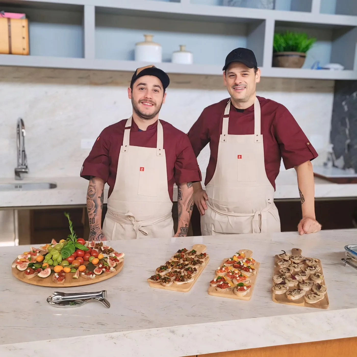 Chefs da G2 na cozinha ao lado das tábuas empratadas para o serviço
